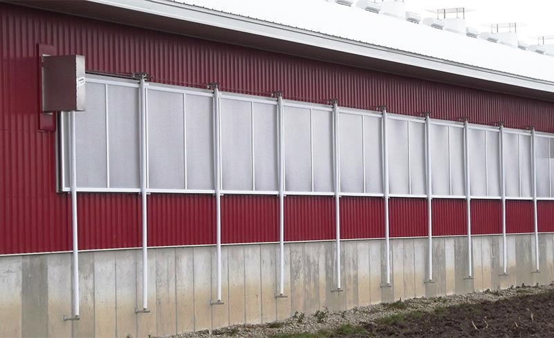 Semi-transparent panels block the sidewall opening of a swine barn to control air circulation while allowing natural light in.