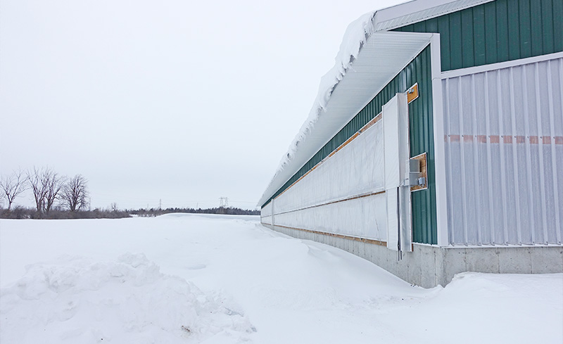 Insulated curtain system keep out cold drafty air of a barn covered in snow.