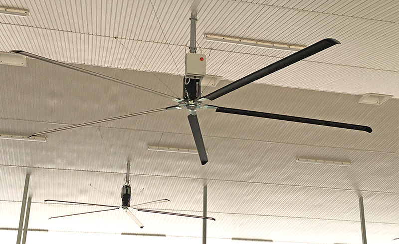 2 HVLS fans hanging from a ceiling.
