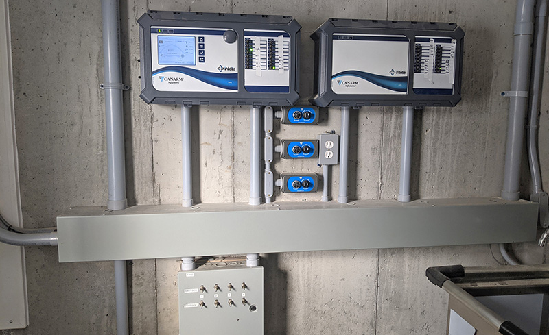Plusieurs commandes installées sur un mur de grange pour contrôler les systèmes de ventilation naturelle et les ventilateurs